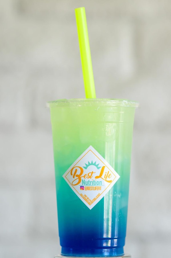 A blue and green iced loaded energy drink in a Best Life Nutrition cup